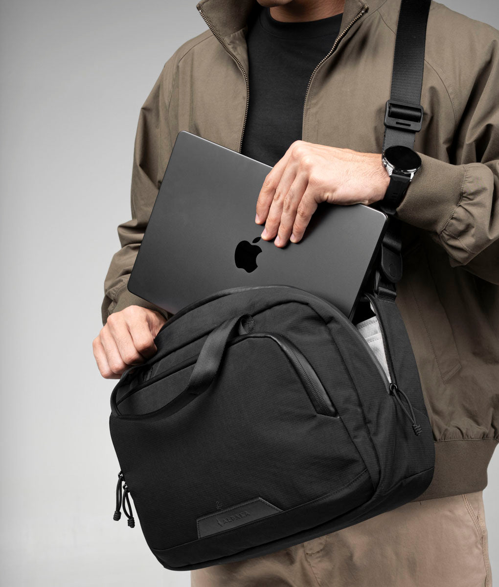 A laptop being placed into the open black Bravo Brief 14