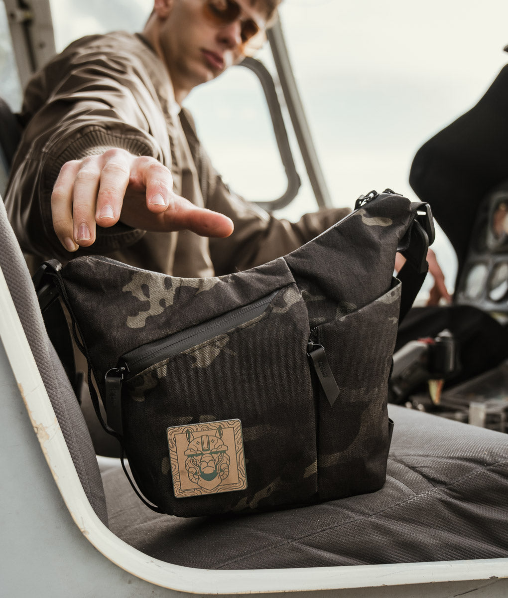 The ClogTwo Edition satchel open on the seat of a helicopter cockpit