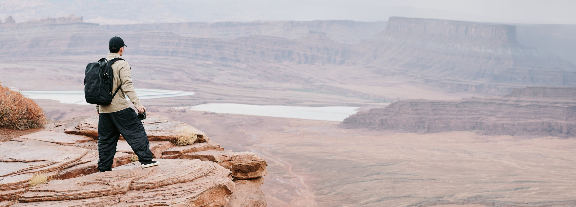 A traveller carrying ALPAKA gear through a canyon landscape